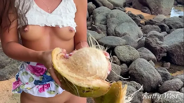 Горячая Голая девушка нашла кокос на общественном пляже и вылила сок на свое тело общая трубка